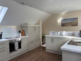 A kitchen with cabinets, stove, and appliances at Ysgubor - The Barn Boncath near Crymych