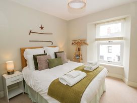 A bedroom with a bed and coat rack at Rose Cottage St Dogmaels near Cardigan