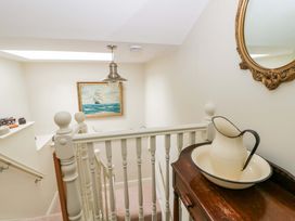 A hallway with a staircase and a framed painting at Rose Cottage in St Dogmaels near Cardigan