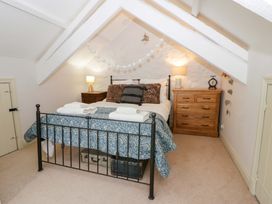 A bedroom with a bed and dresser at Rose Cottage St Dogmaels near Cardigan