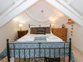 A bedroom with a bed and dresser at Rose Cottage St Dogmaels near Cardigan