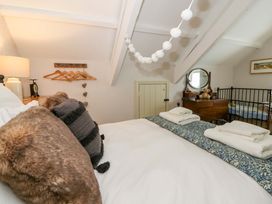 A bedroom with a bed and dresser at Rose Cottage St Dogmaels near Cardigan