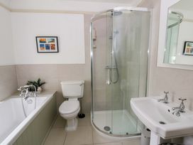 A bathroom with a bathtub, shower, toilet, and sink at Rose Cottage in St Dogmaels near Cardigan