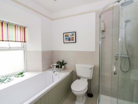 A bathroom with a bathtub, shower, and toilet at Rose Cottage in St Dogmaels near Cardigan