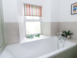 A bathroom with a bathtub and a window at Rose Cottage in St Dogmaels near Cardigan