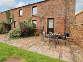 An outdoor patio area with a table and chairs at Stable Cottage Bolton Low Houses