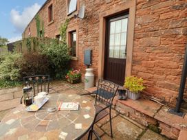 An outdoor seating area with a table and a door at Stable Cottage in Bolton Low Houses