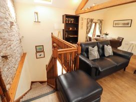 A living room with a staircase and sofa at Stable Cottage in Bolton Low Houses