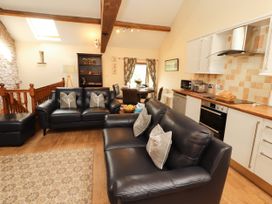 A living room with sofas and a dining area at Stable Cottage, Bolton Low Houses