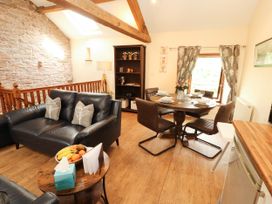 A living room with a dining table and sofa at Stable Cottage in Bolton Low Houses