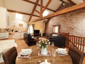 A living room with a kitchen area and dining space at Stable Cottage in Bolton Low Houses