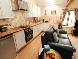 A kitchen with a sofa and dining table at Stable Cottage Bolton Low Houses