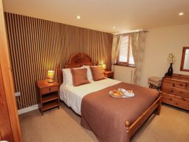 A bedroom with a bed and bedside table at Stable Cottage in Bolton Low Houses