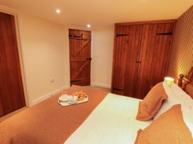 A bedroom with a bed and a wardrobe at Stable Cottage Bolton Low Houses