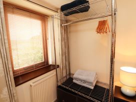 A wardrobe with towels and hangers at Stable Cottage in Bolton Low Houses