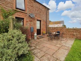 An outdoor seating area with a table and chairs at Stable Cottage in Bolton Low Houses