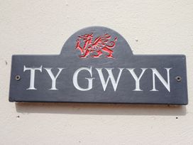 A nameplate with TY GWYN and a dragon crest at Ty Gwyn in Llangwm near Bala