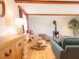 A living room featuring a rocking chair and a wood stove at Ty Gwyn Llangwm near Bala
