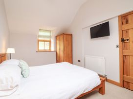 A bedroom with a bed and wardrobe at Ty Gwyn in Llangwm near Bala