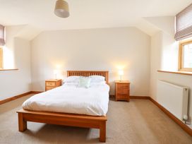 A bedroom with a bed and nightstands at Ty Gwyn in Llangwm near Bala