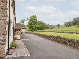 An outdoor area with a road leading to a building and trees at Ty Gwyn in Llangwm near Bala