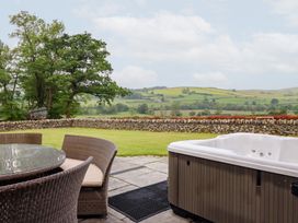 An outdoor area with a table and chairs beside a hot tub at Ty Gwyn in Llangwm near Bala