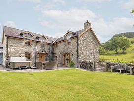 A house with a hot tub and patio furniture at Ty Gwyn in Llangwm near Bala