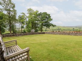 A garden with grass and trees at Ty Gwyn in Llangwm near Bala
