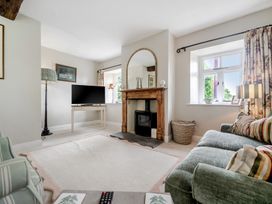 A living room with a television and fireplace at Dove Cottage at the Graythwaite Estate near Hawkshead