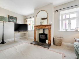 A living room with a television and fireplace at Dove Cottage at the Graythwaite Estate near Hawkshead