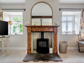 A living room with a fireplace and television at Dove Cottage at the Graythwaite Estate near Hawkshead