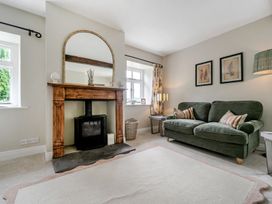 A living room with a fireplace and a sofa at Dove Cottage at the Graythwaite Estate near Hawkshead