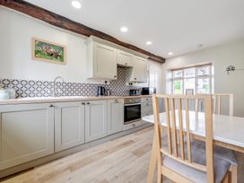 A kitchen with cabinets and a dining area at Dove Cottage at the Graythwaite Estate near Hawkshead