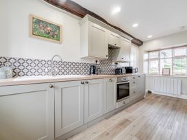 A kitchen with cabinets, sink, and appliances at Dove Cottage at the Graythwaite Estate near Hawkshead