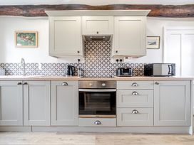 A kitchen with cabinets and appliances at Dove Cottage at the Graythwaite Estate near Hawkshead