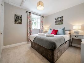 A bedroom with a bed and bedside lamps at Dove Cottage at the Graythwaite Estate near Hawkshead