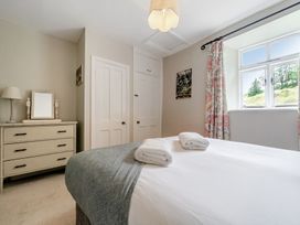 A bedroom with bed, dresser and window at Dove Cottage at the Graythwaite Estate near Hawkshead