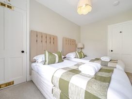 A bedroom with two beds and a bedside table at Dove Cottage at the Graythwaite Estate