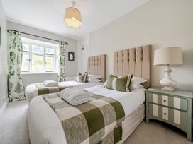 A bedroom with twin beds and green decor at Dove Cottage at the Graythwaite Estate near Hawkshead