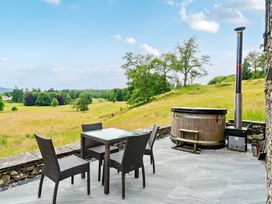 An outdoor seating area with a hot tub at Dove Cottage at the Graythwaite Estate near Hawkshead