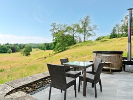 An outdoor seating area with a table and chairs at Dove Cottage at the Graythwaite Estate near Hawkshead