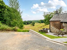 A cottage with outdoor seating and a gravel path at Dove Cottage at the Graythwaite Estate near Hawkshead