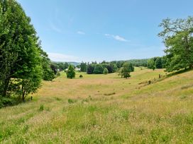 A field with trees and a distant house at Dove Cottage at the Graythwaite Estate Graythwaite Estate near Hawkshead