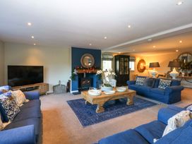 A living room with a television and fireplace at Nant-yr-Rhedyn in Red Wharf Bay