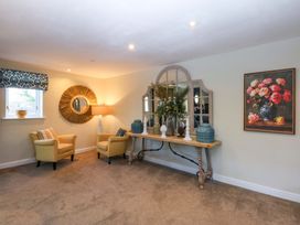 A living room with chairs and a table featuring decorative items at Nant-yr-Rhedyn in Red Wharf Bay