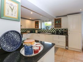 A kitchen with appliances and dining items at Nant-yr-Rhedyn in Red Wharf Bay