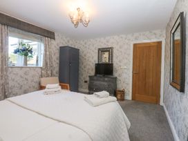 A bedroom with a bed and wardrobe at Nant-yr-Rhedyn in Red Wharf Bay