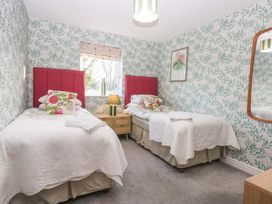 A bedroom with two beds and a window at Nant-yr-Rhedyn in Red Wharf Bay