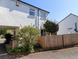 A white two-story house with a wooden fence a garden hose and a small tree at Moorside in Horrabridge near Tavistock