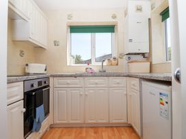 A kitchen with white cabinets countertop oven toaster and windows at Moorside Horrabridge near Tavistock
